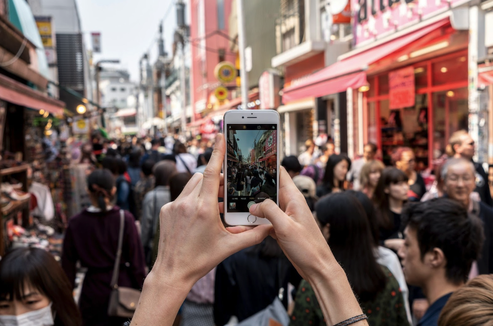 人混みの中でスマホを掲げられているスマホ画面の画像