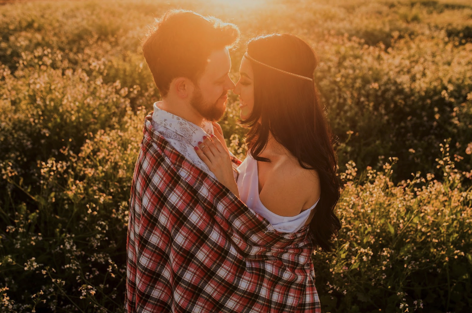 お花畑で抱き合う男女の写真